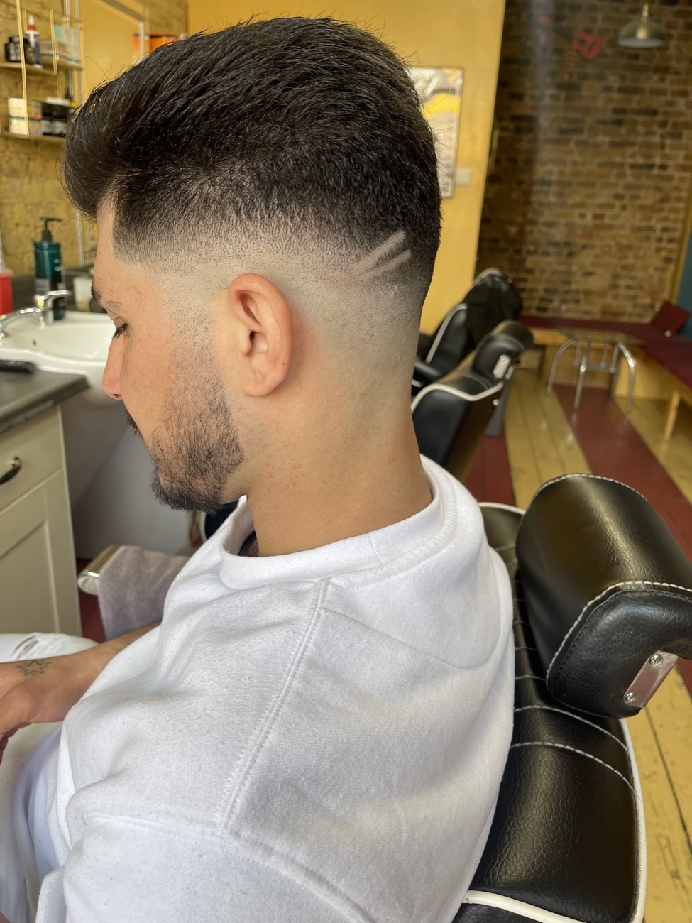 Clean skin fade with a sharp line-up, finished at Crew Cuts barbershop in Hackney